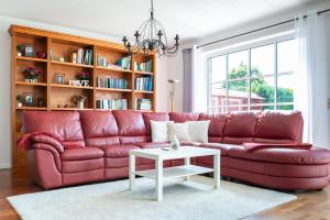 um sofá de couro vermelho numa sala de estar com uma mesa em Ferienhaus Eisenach em Eisenach