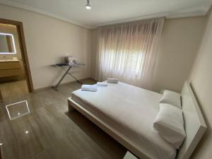 - une chambre dotée d'un grand lit avec des draps et des oreillers blancs dans l'établissement Magnifique villa a San Juan Mutchavista playa, à El Campello
