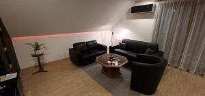a living room with two black couches and a coffee table at Ferienwohnung Lange in Kurort Jonsdorf
