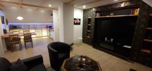 a living room with a large television and a kitchen at Ferienwohnung Lange in Kurort Jonsdorf