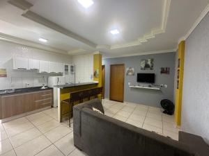 uma sala de estar com um sofá e uma cozinha em AP inteiro com ar condicionado em Goiânia