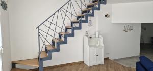 un escalier dans un salon doté d'une balustrade bleue dans l'établissement La Lampara, à Giovinazzo