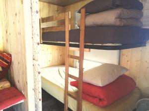 ein Etagenbett aus Holz mit einem Stapel Kissen in der Unterkunft Ferme de Samson in Saint-Péray