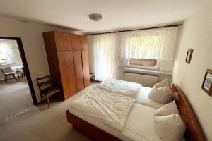 sypialnia z łóżkiem i krzesłem w obiekcie Haus PANORAMA - Appartement Auszeit 4 w mieście Braunlage