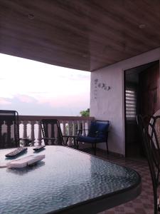 Habitación con balcón con mesa y sillas. en La casa de Wili Taboga 62,61,00,07 en Taboga