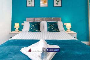 1 dormitorio azul con 1 cama grande y paredes azules en Luxury 6 Bedroom Contractor House By Your Lettings Short Lets & Serviced Accommodation Peterborough With Free WiFi, en Peterborough