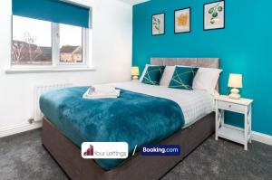 1 dormitorio con 1 cama grande y pared azul en Luxury 6 Bedroom Contractor House By Your Lettings Short Lets & Serviced Accommodation Peterborough With Free WiFi, en Peterborough