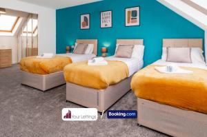 2 camas en una habitación con una pared azul en Luxury 6 Bedroom Contractor House By Your Lettings Short Lets & Serviced Accommodation Peterborough With Free WiFi, en Peterborough
