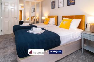 2 camas en una habitación de hotel con almohadas amarillas en Luxury 6 Bedroom Contractor House By Your Lettings Short Lets & Serviced Accommodation Peterborough With Free WiFi, en Peterborough