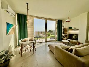 a living room with a couch and a table at Green Coast, Palase 148 in Palasë