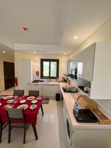 a kitchen with a table with a red table cloth at Hawana salalah Apartment in Salalah