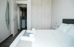 a bedroom with a white bed with towels on it at Filokalia 7 - Premium Vacation House with Sea View in Karistos