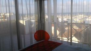 a bedroom with a large window with a view of a city at Hôtel Le Nautic in Arcachon