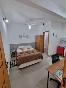 a bedroom with a bed and a desk and a table at Studio fantástico in São Paulo