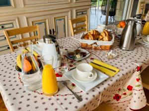 a table with a plate of bread and a basket of orange juice at Domaine de la Chesnaie in Josselin