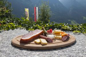 a plate of cheese and fruit on a table at Gasthaus Jaufenblick in San Martino