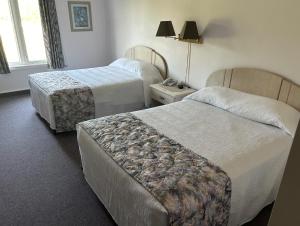 Ένα ή περισσότερα κρεβάτια σε δωμάτιο στο Centennial Motel