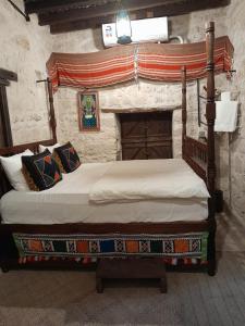 a bedroom with two beds in a stone room at نزل كوفان التراثي Koofan Heritage Lodge in Salalah