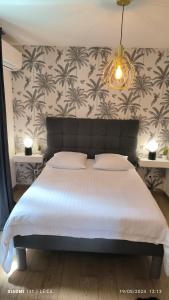 エルバルンガにあるCasa Lucianiのベッドルーム1室(ヤシの壁紙を用いた白い大型ベッド1台付)