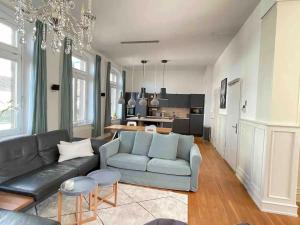 a living room with a blue couch and a kitchen at Jugendstil-Appartement mit Terrasse und Balkon in Siegburg