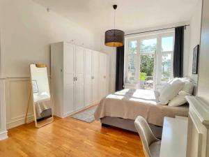 a bedroom with a bed and a large window at Jugendstil-Appartement mit Terrasse und Balkon in Siegburg +24 photos