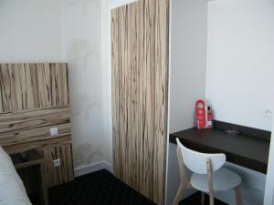 a bedroom with a bed and a desk and a chair at Hôtel Le Nautic in Arcachon