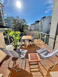 a deck with a table and chairs on a balcony at Jugendstil-Appartement mit Terrasse und Balkon in Siegburg