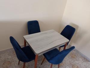 a table with four blue chairs in a room at Bilal appartement in Larache +12 photos