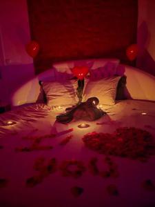 a woman laying on a bed with candles and roses at Loft Romantique ~Jacuzzi privatif~ Séjour amoureux in Vieille-Toulouse