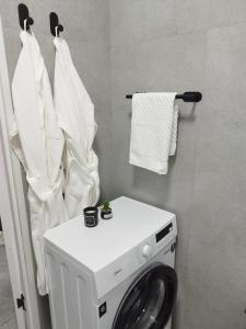a washing machine in a bathroom with white towels at Like Home Hostel na Shevchenko, 162Б in Almaty