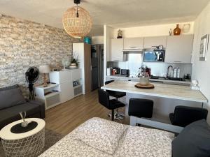 a living room with a couch and a kitchen at Appartement magnifique VUE MER Canet plage in Canet-en-Roussillon