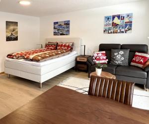 ein Schlafzimmer mit einem Bett und einem Sofa in der Unterkunft Haus Vira in Zermatt