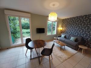 a living room with a couch and a table at L'Aquarelle - Appartement cosy, GroupamaStadium LDLC Arena in Meyzieu