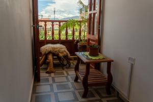 Zimmer mit einem Tisch und einer Tür mit einer Pflanze in der Unterkunft ValMas H in Chachapoyas