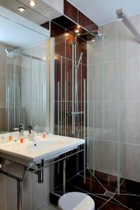 a bathroom with a sink and a shower at Hôtel Le Nautic in Arcachon