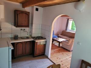 una cucina con arco che conduce a un soggiorno di Domki Letniskowe w Chańczy a Chańcza