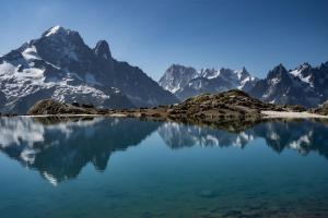 vistas a un lago de montaña con montañas cubiertas de nieve en el fondo en Le calme, le confort, la nature, skis aux pieds, à 15 kilomètres de Chamonix en Vallorcine