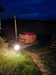 bañera de hidromasaje con luz en un campo por la noche en Domki Na Wiosce, 