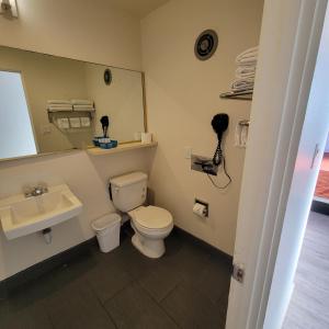 a bathroom with a toilet and a sink and a mirror at Guest Harbor Inn- Port Of Los Angeles San Pedro in San Pedro