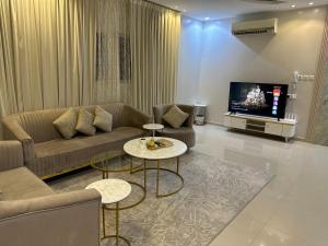 a living room with a couch and a tv at شقق العارض (2) in Riyadh