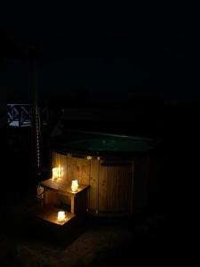 una bañera de madera con velas en la oscuridad en Domki Na Wiosce, 