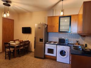 a kitchen with a refrigerator and a table with a dining room at Island apartment N.Skioni in Nea Skioni