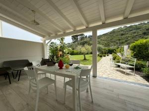 una mesa blanca y sillas en un patio en Villa Elemiri en Buonfornello
