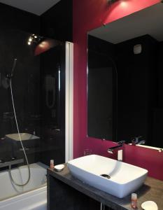 a bathroom with a white sink and a bath tub at Hôtel Le Nautic in Arcachon