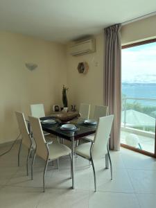 a dining room with a table and white chairs at Privat apartament Golf Coast in Kavarna