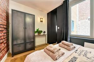 a bedroom with a bed with two towels on it at L'urbain in Arras
