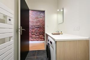 a kitchen with a sink and a brick wall at L'urbain in Arras