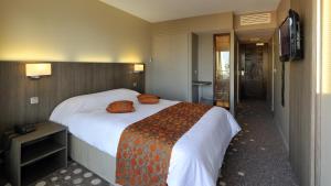 a hotel room with a large bed with orange pillows at Hôtel Le Nautic in Arcachon