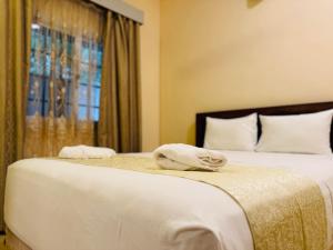 um quarto com 2 camas com lençóis brancos e uma janela em Royal Point Arugambay em Arugam Bay