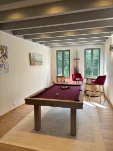 uma sala de estar com uma mesa de bilhar no meio em Hotel Le Manasses em Curtil-Vergy